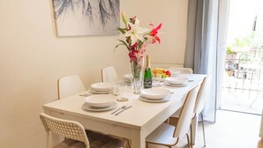 A dining table set with plates, glasses, cutlery, and a vase with flowers. - Dalia 3 BR, 2 BA 10 min walk from Old Town Square (Praha 1)