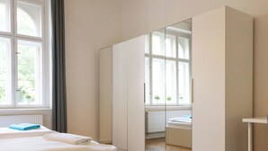 A bedroom with a bed, a dresser, a mirror, and a window. - Dalia 3 BR, 2 BA 10 min walk from Old Town Square (Praha 1)