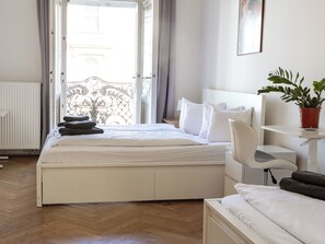 Ein Hotelzimmer mit einem Bett, einem Sessel, einem Nachttisch und einer Topfpflanze.