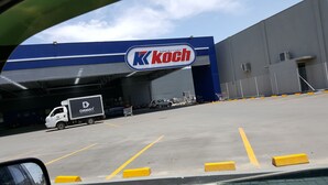 Ein Kkoch Supermarkt mit einem großen, blauen Gebäude und einem Lieferwagen davor.