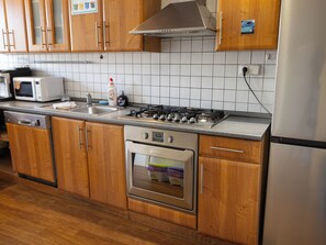 A kitchen with wooden cabinets, a stainless steel range, a built-in oven, and a microwave.