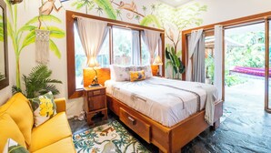 A bedroom with a bed, nightstands, a desk, and a chair. There are curtains, a window, and a view of the outdoors. - 🌴16 Bed Compound Oasis 🌴Downtown Jaco with Private Pool & Hot Tub (Jaco Beach)