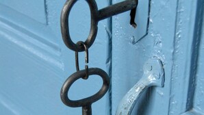 Una puerta azul con una cerradura metálica y un picaporte de metal.