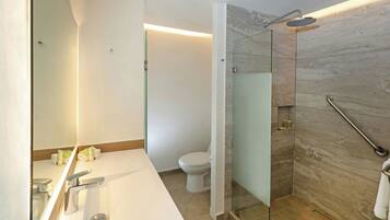 A modern bathroom with a glass-enclosed shower, a white sink, and a toilet.