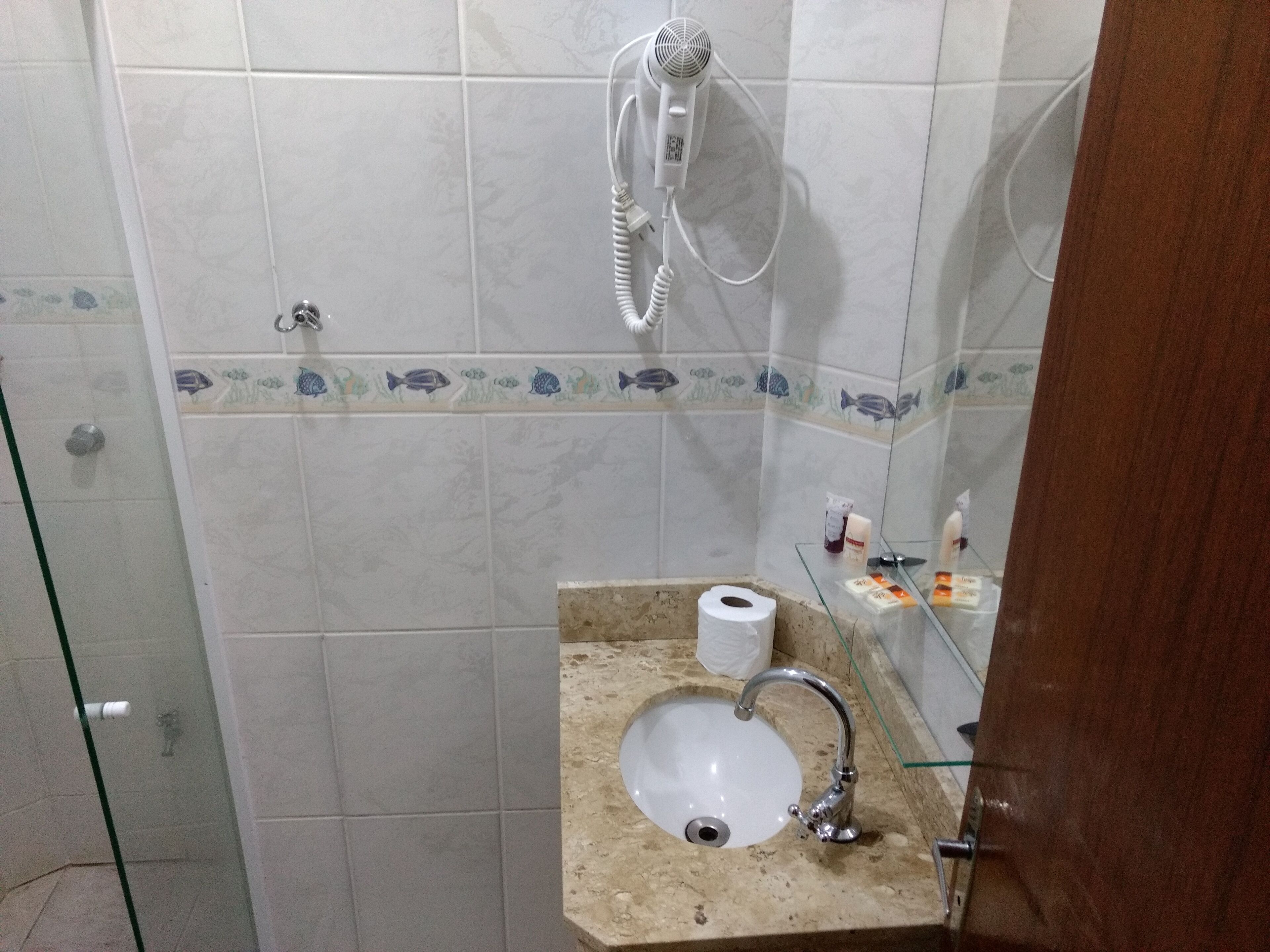 A bathroom with a shower, a sink, and a toilet.