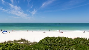 A beach with white sand and clear blue water. - Seaside Beach House 201 · 2 Full Baths · Gulf Front (Holmes Beach)
