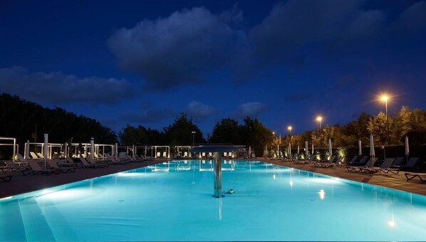 Relax by the pool surrounded by lush trees and lounge in comfort.