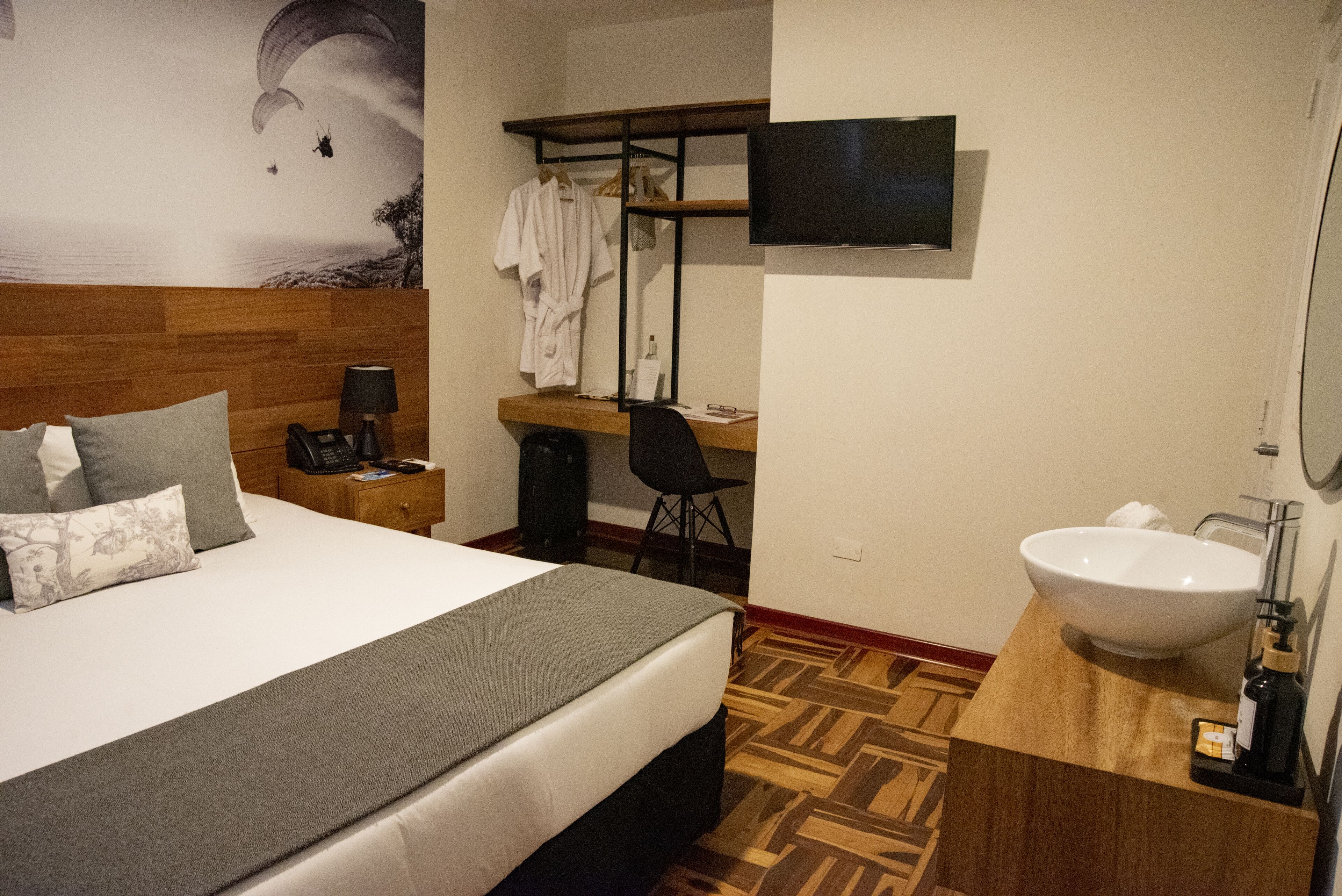 Une chambre d’hôtel équipée d’un lit, d’un bureau, d’une chaise, d’une télévision et d’une salle de bain avec un lavabo.