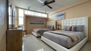 Una camera da letto con un letto grande, due comodini, un ventilatore a soffitto e un quadro appeso al muro.