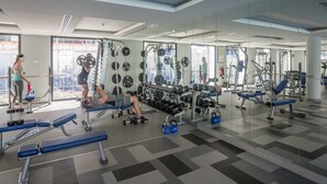 Una palestra moderna con attrezzature per sollevamento pesi, panche per esercizi e specchi.