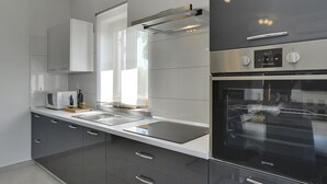 Una cocina moderna con horno empotrado, microondas y armarios de acero inoxidable.