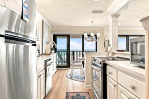 Una cocina con vista al océano, un candelabro y un refrigerador grande.