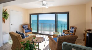 A balcony with wicker furniture, a ceiling fan, and a view of the ocean. - Leeway RE,  Beautiful Gulf Front Condo (Gulf Shores)
