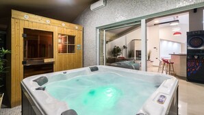 A hot tub with a wooden exterior, a tiled wall, and a modern interior with a dartboard. - Villa for big demands with large pool, sauna, whirlpool, fitness equipment, billiards and professional outdoor kitchen (Liznjan)