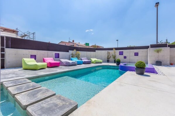 A swimming pool with colorful lounge chairs and a small hot tub. - City finca with private heated pool, jacuzzi (Pula)