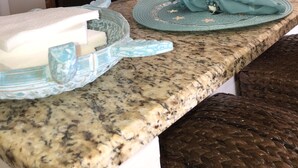 A kitchen with granite countertops, stainless steel appliances, and wooden cabinets. - 100 PLUS 5 STARS! BEACHFRONT! FREE BEACH CHAIRS! STAND UP SHOWER! FULLY STOCKED! (Panama City Beach)