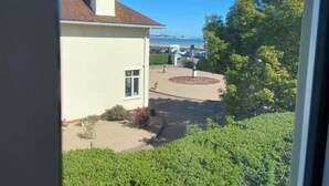 A building with a chimney, a small window, and a paved area with a circular flower bed. - Seawold Guest House (St. Peter)