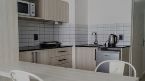 Una cocina moderna equipada con microondas, hervidor y lavavajillas.
