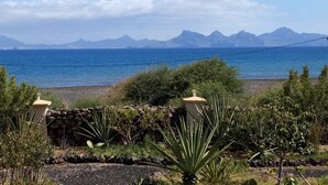 Un paysage côtier offrant une vue sur la mer et les montagnes lointaines.
