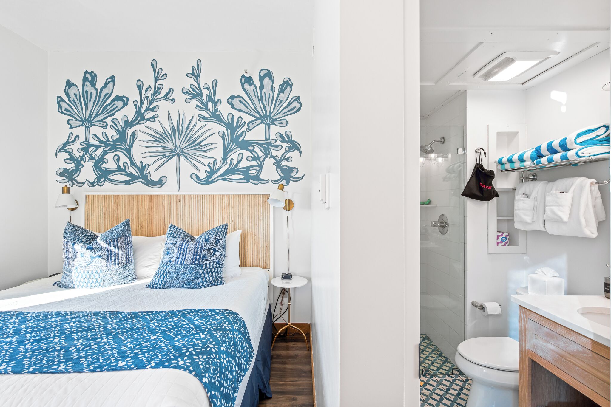 Ein Hotelzimmer mit Bett, rundem Tisch, Dusche und Bad mit Handtuchhalter.