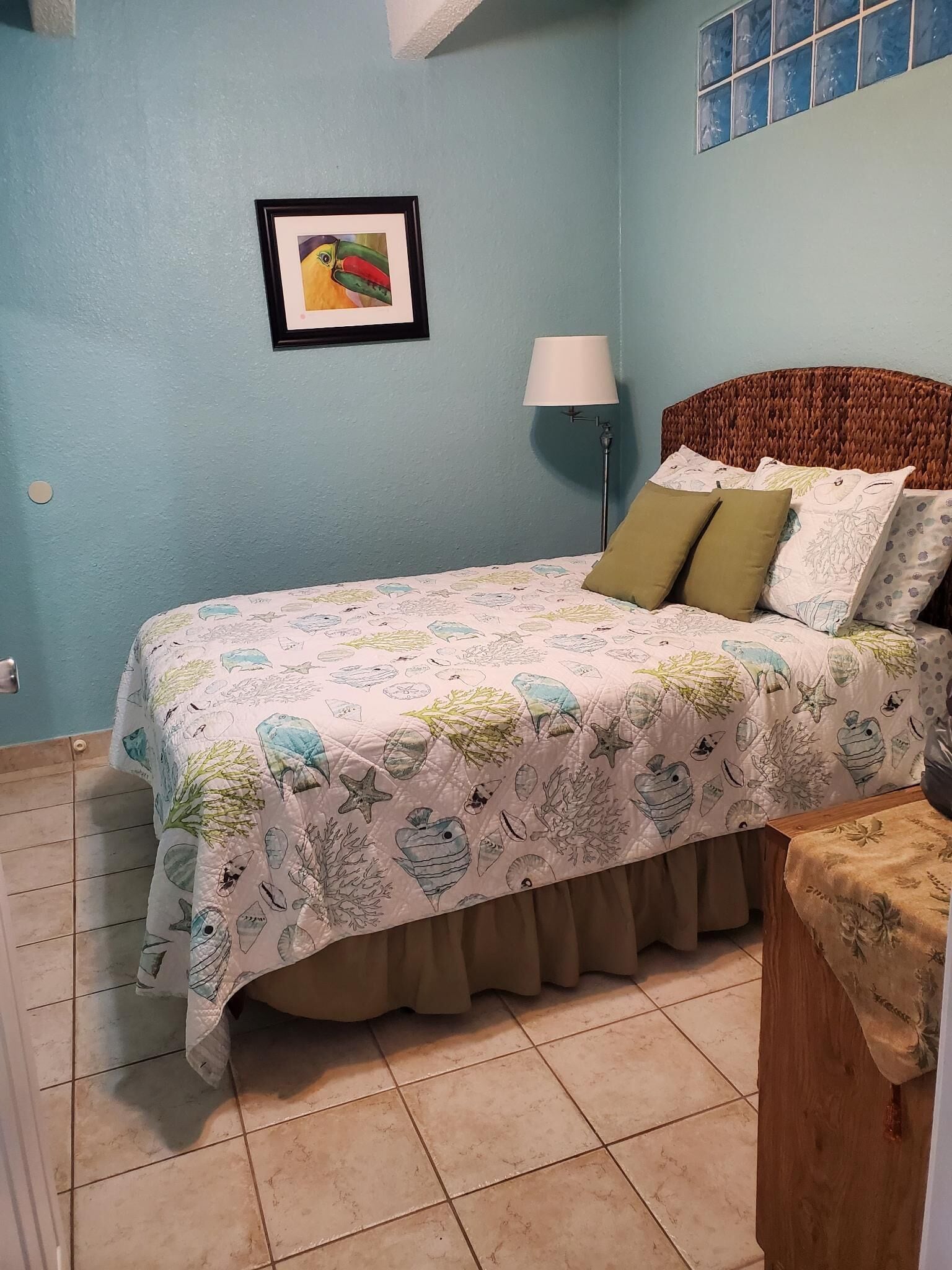 A bedroom with a bed, a bedside lamp, and a framed picture on the wall.
