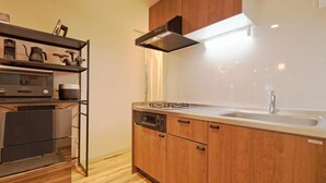 Una cocina moderna con armarios de madera, un lavamanos de acero inoxidable y un horno empotrado.