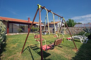 Relax in a serene outdoor space with a swing set and comfortable lounge seating.