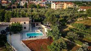 A residential area with a swimming pool, surrounded by trees and houses.