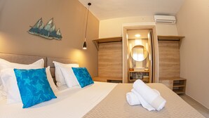 Habitación de hotel con una cama grande, cabecera de madera, un espejo y una decoración náutica en la pared.