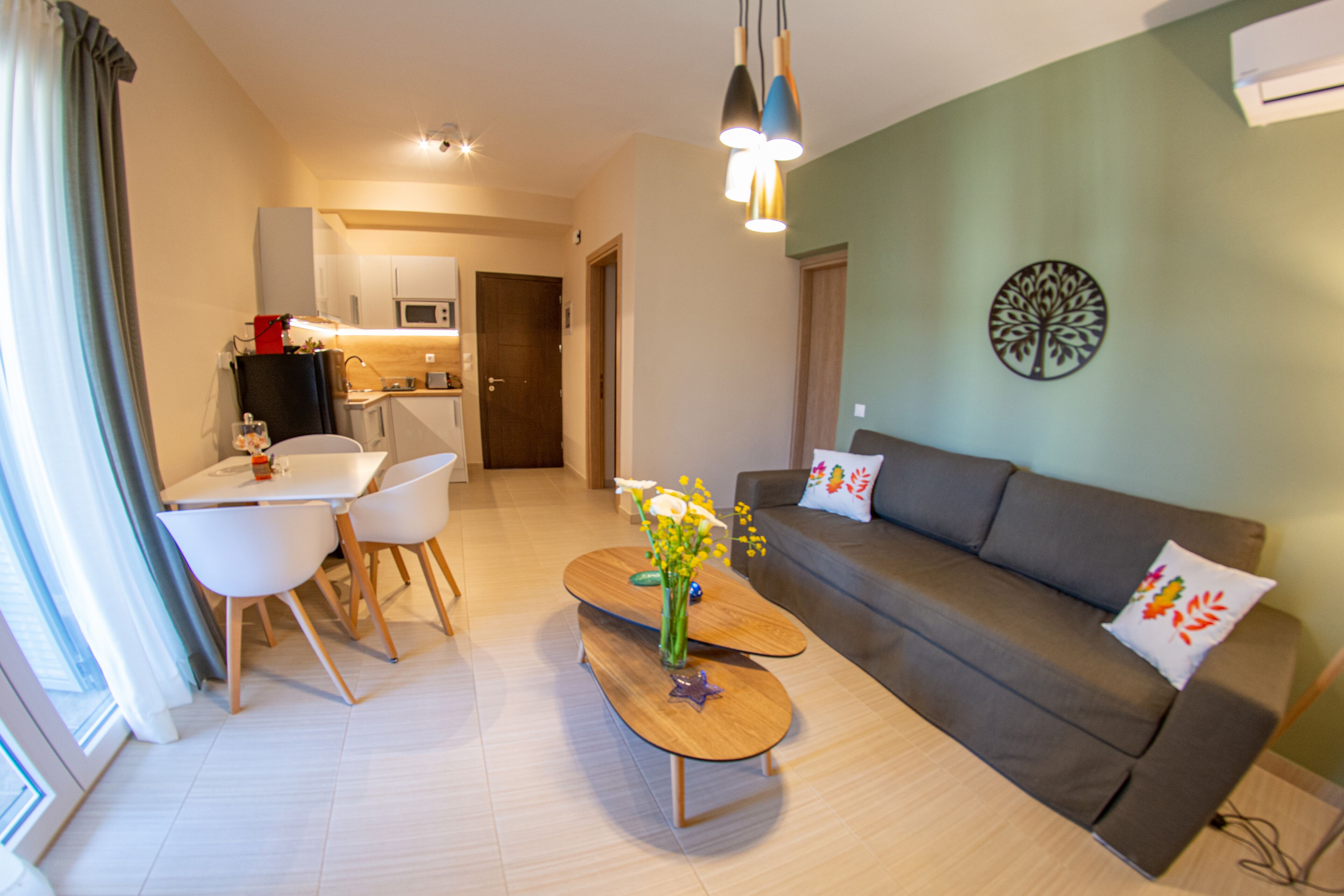 A modern living room with a sofa, coffee table, and dining area.