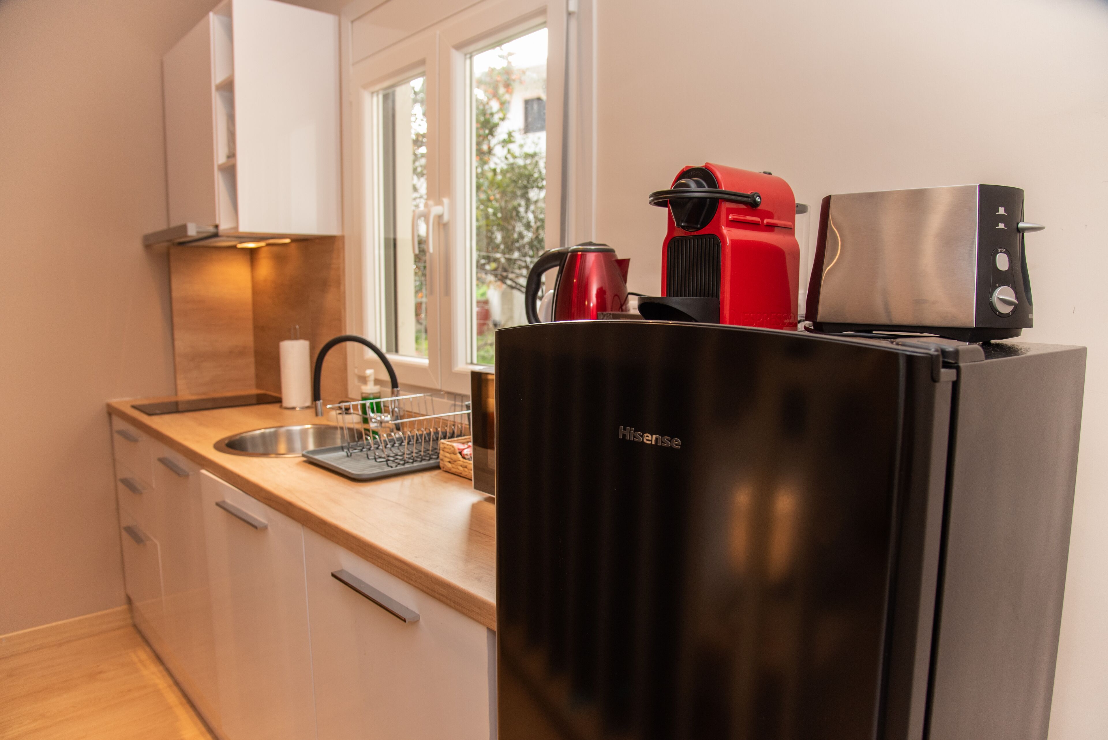 A modern kitchen with a sink, countertop, and a black refrigerator.
