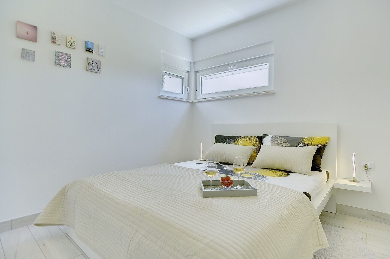 Ein Schlafzimmer mit einem Bett, einem Nachttisch und einem Fenster.