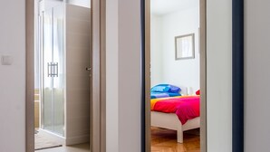 A hallway leading to a bedroom with a bed, a window, and a door. - Newly renovated Apartment with WiFi and BBQ (Pula)
