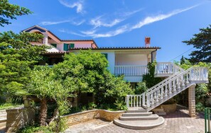 Ein mehrstöckiges Gebäude mit einer Steintreppe, die zu einem Balkon führt.