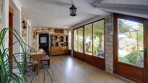 Una habitación amplia con chimenea de piedra, armarios de madera y ventanas grandes con vistas al jardín.