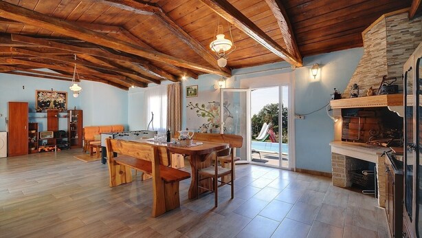Un espacio habitable amplio con techo de madera, una mesa de comedor y una chimenea.