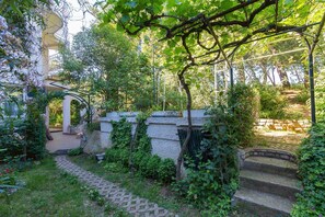 Stroll through the serene garden, surrounded by lush greenery and a picturesque pergola.