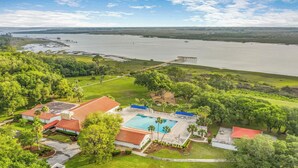 Un resort con piscina, un muelle y vistas a una extensa masa de agua.