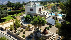 Una casa moderna con piscina, paneles solares y un jardín cuidado.