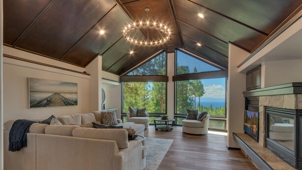 A spacious living room with a large sofa, a round coffee table, and a fireplace. - Incline Oasis - Incline Village Lakeview - TLUXP (Incline Village)