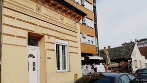 A building with a beige facade, a white door, and a window with the number 24A.