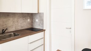 A compact kitchen with a sink, countertop, and cabinets.