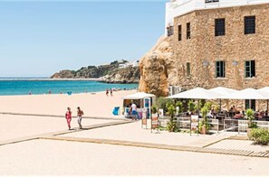 A stone building with a beach in the background.