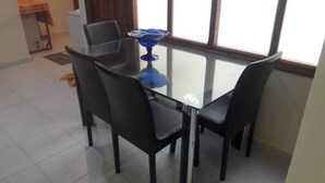A dining area with a glass table and four black chairs. - Furnished apartment in Essaouira (Essaouira)