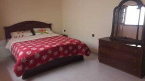 A bedroom with a bed, a dresser, and a window. - Furnished apartment in Essaouira (Essaouira)