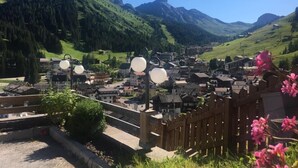 A mountainous village with traditional architecture, a wooden fence, and a clear view of the valley. - Hotel Olympia (Livinallongo del Col di Lana)