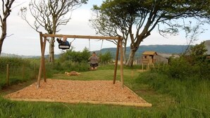 A wooden swing set in a grassy area with a clear view of the surrounding landscape. - Barnacle -  a cottage that sleeps 4 guests  in 2 bedrooms (Southwick-Sandyhills)