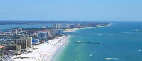 Ranta lähistöllä, aurinkotuoleja, rantapyyhkeitä