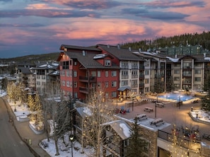 A multi-story hotel with a central courtyard, outdoor seating, and a pool area. - Fraser Crossing 3227 Ski In Ski Out Winter Park (Winter Park)