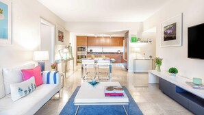 Un soggiorno moderno con un divano, un tavolino da caffè e una zona pranzo con sedie e tavolo.